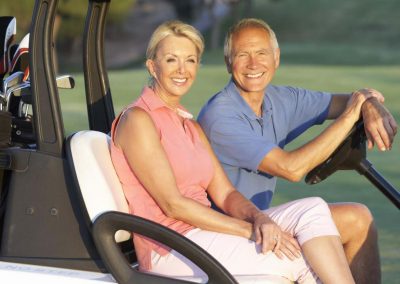 mature couple in golf cart